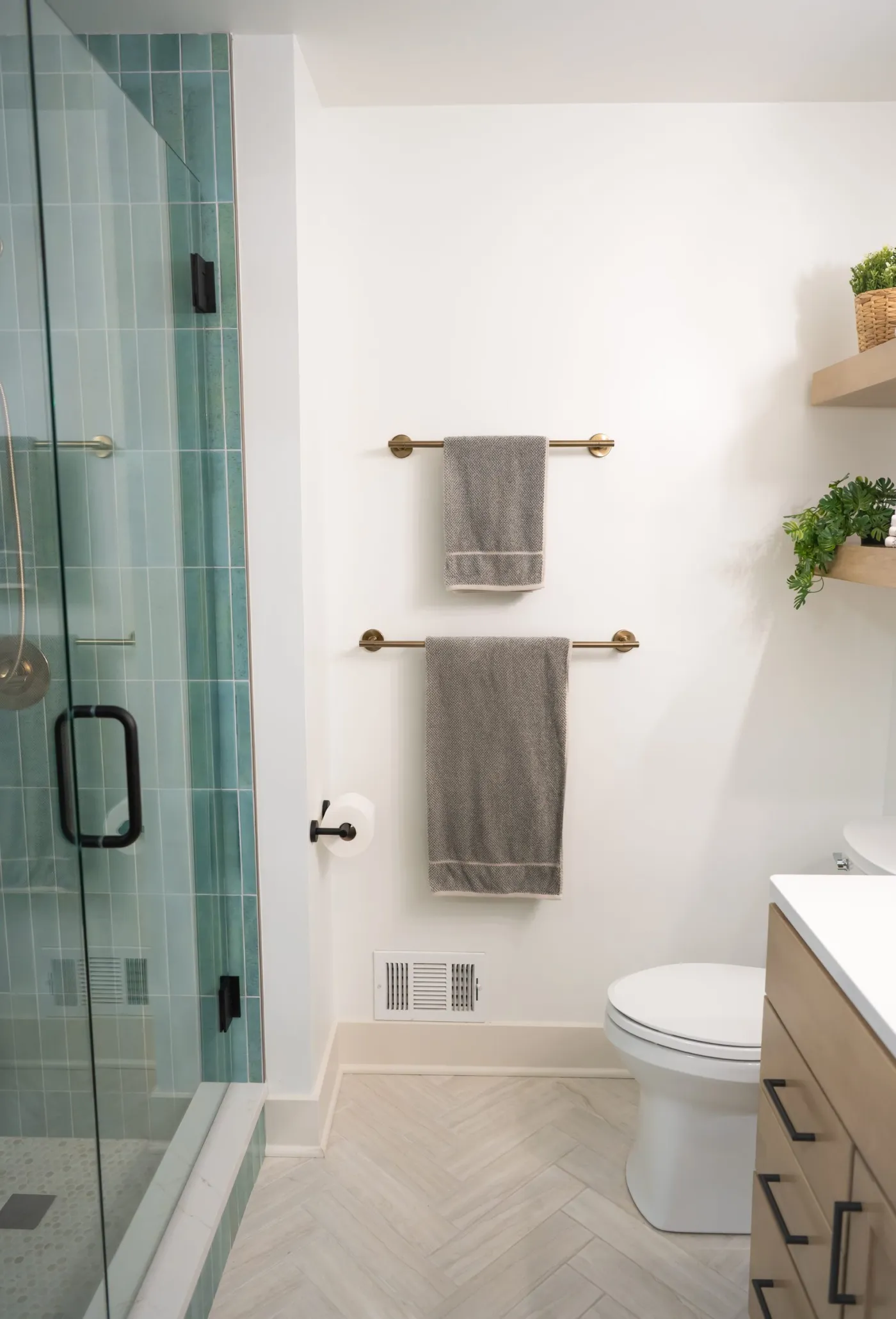 Remodeled bathroom in Salem Township with a green tile walk-in shower and herringbone tile floor