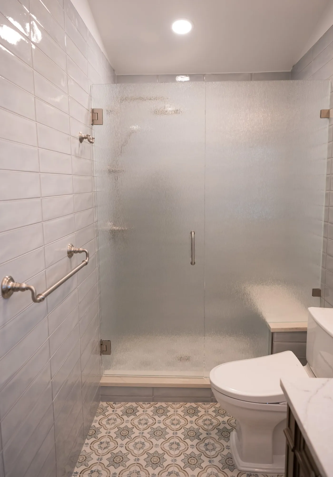 Custom frosted glass shower door in a walk-in tiled shower