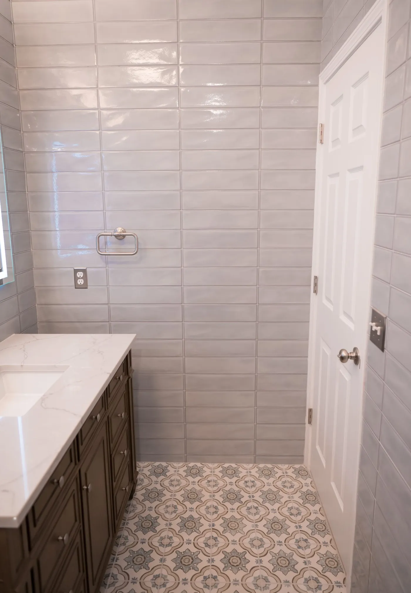 Full-height wall tile beside the vanity in a remodeled bathroom